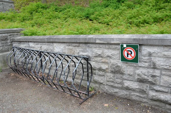 Ingen parkering skylt med metall cykelställ och stenmur — Stockfoto