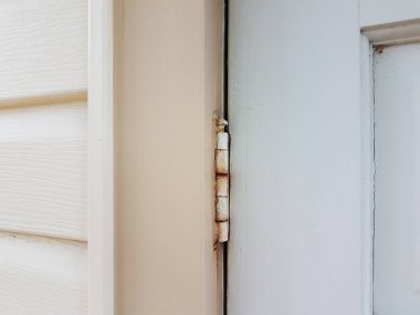 Beyaz kapısında pas olan eski metal menteşe