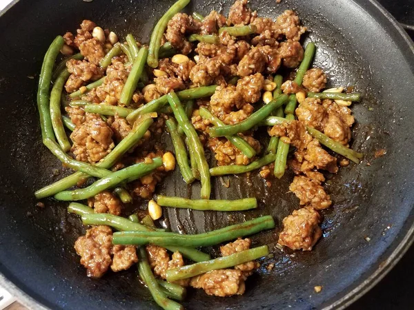 Pork with green beans and peanuts in skillet — Stock Photo, Image