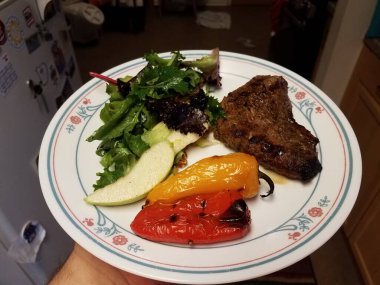 Bir tabak biftek, biber ve salata.