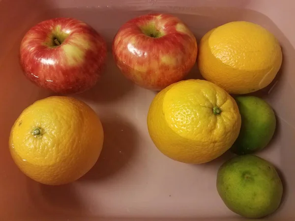 Μήλα και πορτοκάλια και γλυκολέμονα που επιπλέουν στο νερό — Φωτογραφία Αρχείου