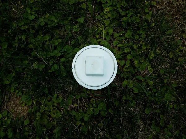 Fehér műanyag csatorna tisztítsa ki cső zöld fű — Stock Fotó