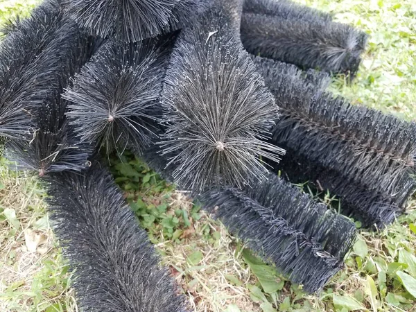 black pipe cleaner for gutters in green grass