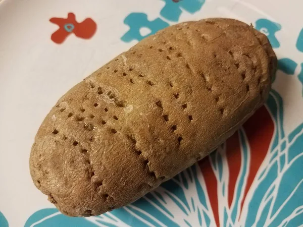Bakad potatis med hål från gaffel på tallrik — Stockfoto