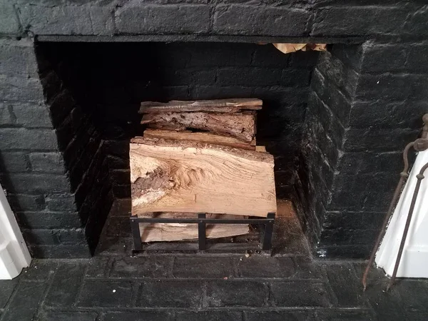 black brick fireplace with chopped firewood logs