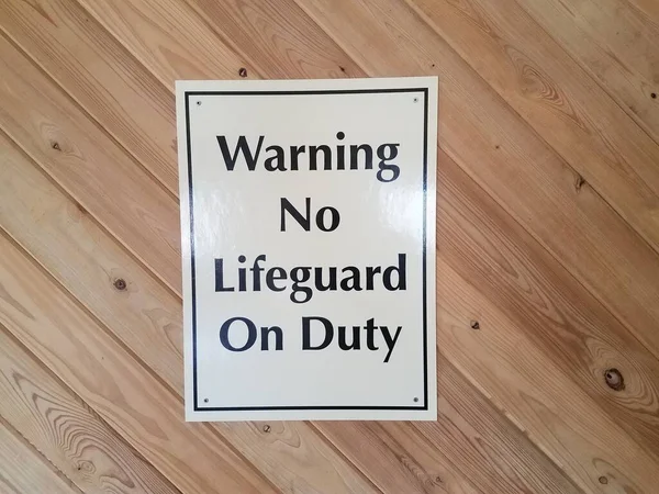 Warning no lifeguard on duty sign on wooden wall — Stock Photo, Image