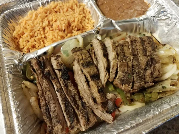 Steak meat and rice and refried beans in foil tray — Stock Photo, Image