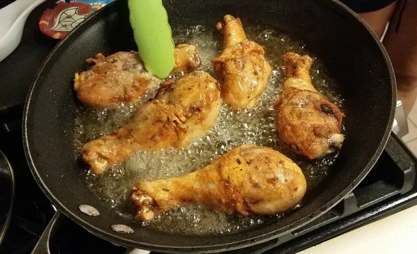 Куриные барабанные палочки, приготовленные в горячем масле на сковородке — стоковое фото