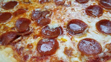 Yağlı sıcak pepperoni ve peynirli pizza dilimleri.
