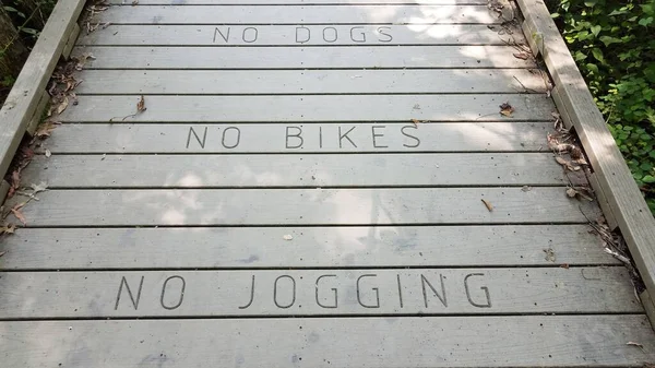 Nincs kutya nincs bicikli nincs kocogás a fa sétányon — Stock Fotó