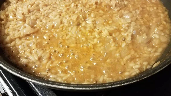 Risotto riz italien à la sauce et oignon dans une poêle — Photo