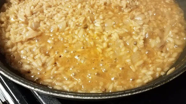 Risotto italienischer Reis mit Soße und Zwiebeln in Pfanne — Stockfoto