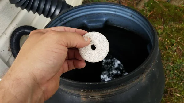 手拿蚊虫片杀虫剂挡在雨桶上 — 图库照片