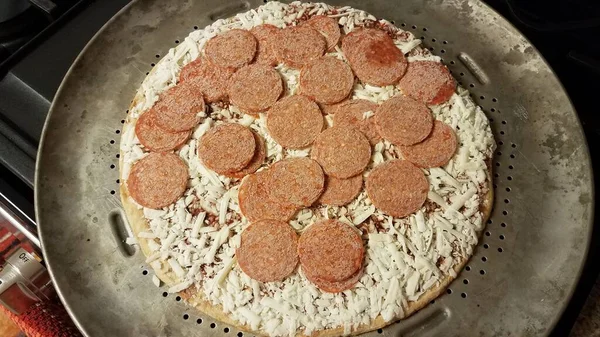 Fagyasztott pepperónis hús pizzán fémsütőtálcán — Stock Fotó