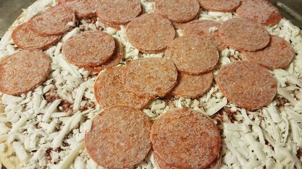 Carne de pepperoni congelada na pizza na bandeja de cozedura metálica — Fotografia de Stock