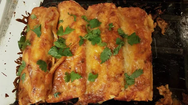 Cheesy enchiladas με το κόλιανδρο σε γυάλινο δοχείο στο φούρνο — Φωτογραφία Αρχείου