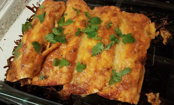 Enchiladas de queijo com coentro em recipiente de vidro no fogão — Fotografia de Stock