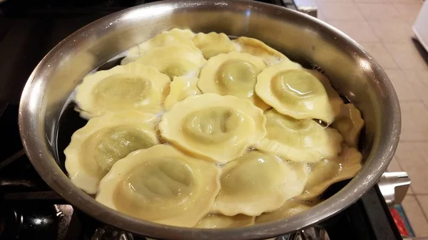 Ravioli spenat pasta matlagning i gryta med vatten på spis — Stockfoto