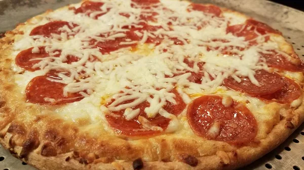 Pepperoni pizza with cheese on metal baking tray — Stock Photo, Image