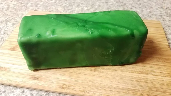 Fromage scellé à la cire verte sur planche à découper — Photo