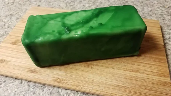 Sýr zapečetěný zeleným voskem na dřevovláknité desce — Stock fotografie