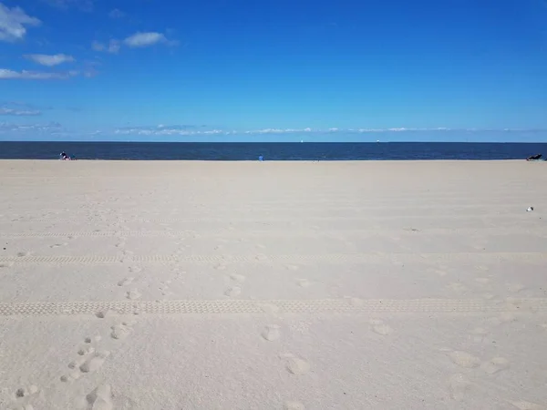 Spiaggia con tracce di pneumatici e acqua dell'oceano e cielo blu — Foto Stock