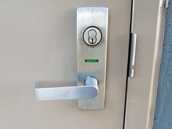 Bathroom door handle with green vacant sign — Stock Photo, Image