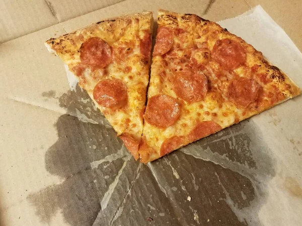 Peperoni-Pizzascheiben mit Fett im Karton — Stockfoto