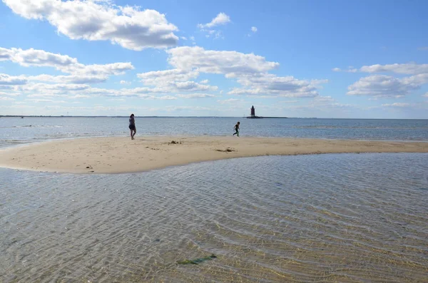 Madre e hijo jugando en la playa con el faro —  Fotos de Stock