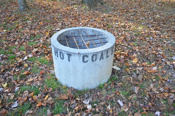 Cement hot coal container with metal bars and leaves — Stock Photo, Image