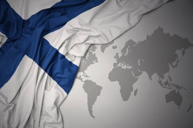 Finlandiya gri dünya harita arka plan üzerinde renkli ulusal bayrak sallayarak.