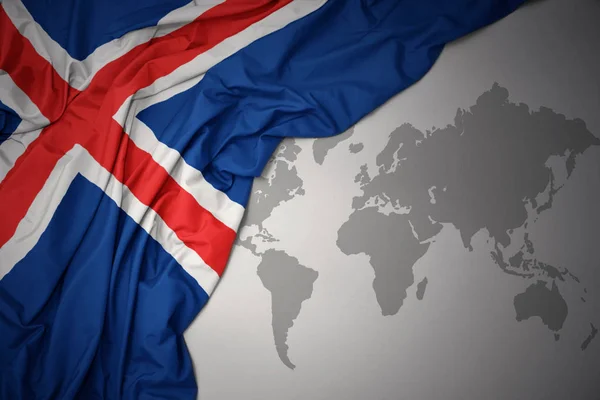 在灰色世界地图背景上挥舞着冰岛的多彩国旗 — 图库照片