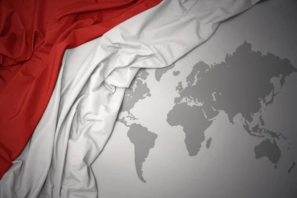 Размахивая Красочным Национальным Флагом Индонезии Сером Фоне Карты Мира — стоковое фото