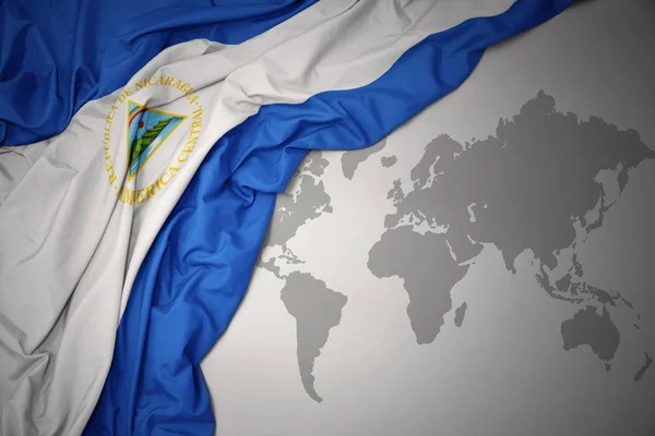 Κουνώντας Πολύχρωμο Εθνική Σημαία Της Νικαράγουας Ένα Φόντο Χάρτη Κόσμο — Φωτογραφία Αρχείου