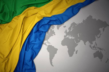 gabon gri dünya harita arka plan üzerinde renkli ulusal bayrak sallayarak.