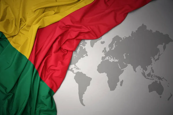 Vifta Med Färgglada Flagga Benin Grå Värld Karta Bakgrund — Stockfoto