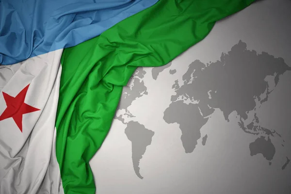 waving colorful national flag of djibouti on a gray world map background.