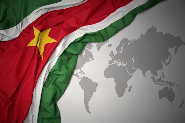 Waving Colorful National Flag Suriname Gray World Map Background — Stock Photo, Image