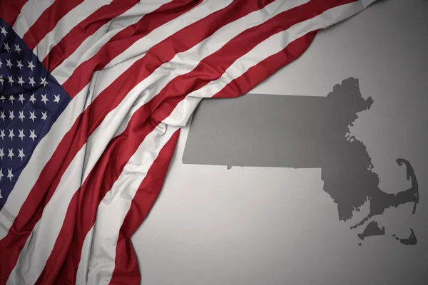 灰色のマサチューセッツ州地図背景にアメリカ合衆国のカラフルな国旗を振ってください — ストック写真