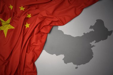 waving colorful national flag of china on a gray map background. clipart