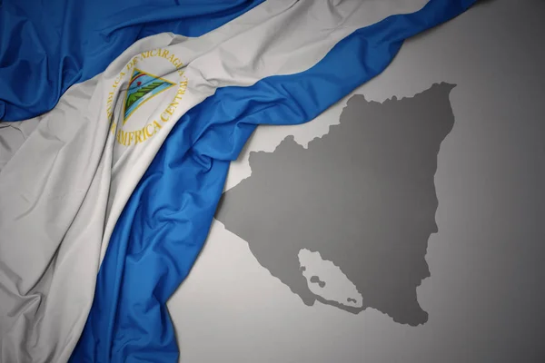 Schwenken Bunte Nationalflagge Nicaraguas Auf Grauem Kartenhintergrund — Stockfoto