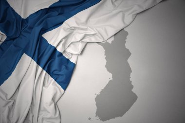 Finlandiya gri harita arka plan üzerinde renkli ulusal bayrak sallayarak.