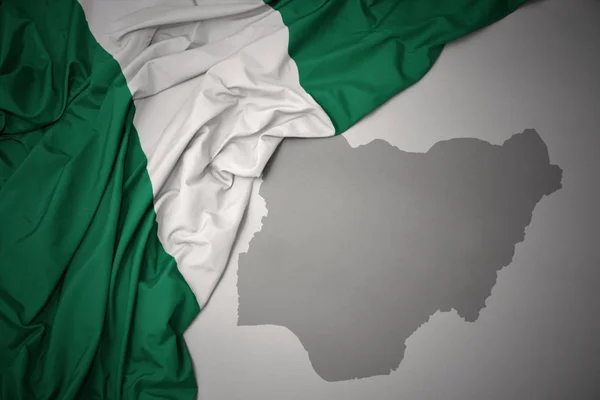 Sventolando Bandiera Nazionale Colorata Della Nigeria Uno Sfondo Mappa Grigia — Foto Stock