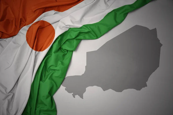 Κουνώντας Πολύχρωμο Εθνική Σημαία Του Νίγηρα Φόντο Γκρι Χάρτη Απεικόνιση — Φωτογραφία Αρχείου