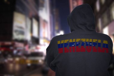 tehlikeli adam ile metin venezuela sırtında bir semt siyah hoodie ile gece cadde üzerinde ayakta