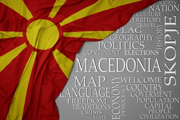 Vifta med färgglada flagga Makedonien på en grå bakgrund med viktiga ord om land — Stockfoto