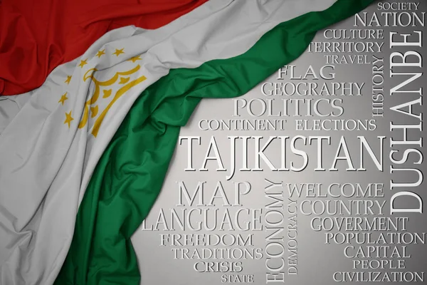Ondeando colorida bandera nacional de Tayikistán sobre un fondo gris con palabras importantes sobre el país — Foto de Stock
