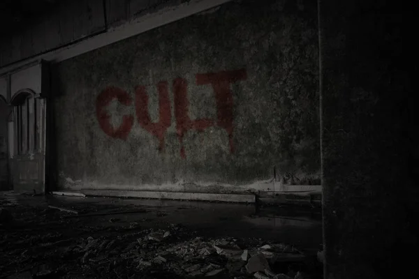 Culto de texto na parede suja em uma casa arruinada abandonada — Fotografia de Stock