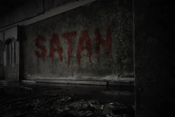 Text satan on the dirty wall in an abandoned ruined house — Stock Photo, Image