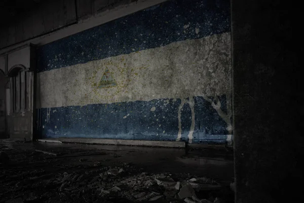 Painted flag of nicaragua on the dirty old wall in an abandoned ruined house. — Stock Photo, Image
